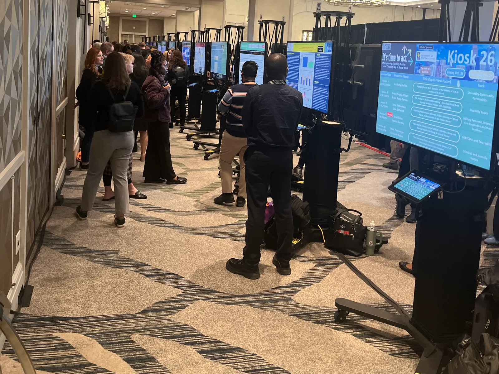Attendees exploring digital poster displays in a conference hall