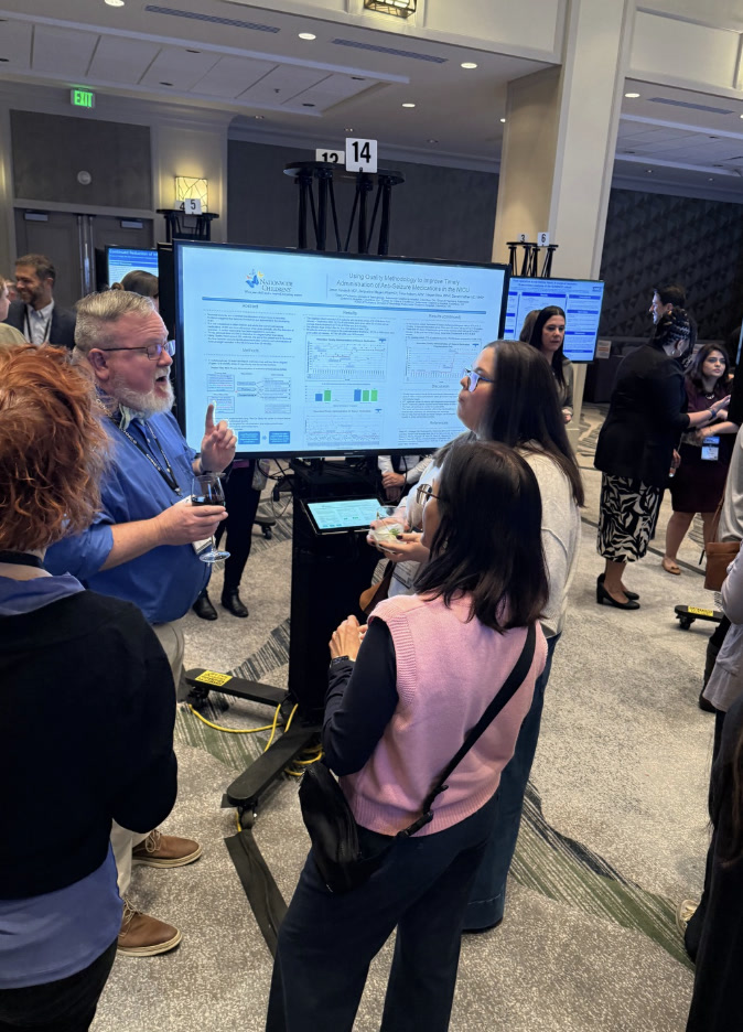 Attendees exploring an interactive digital poster display