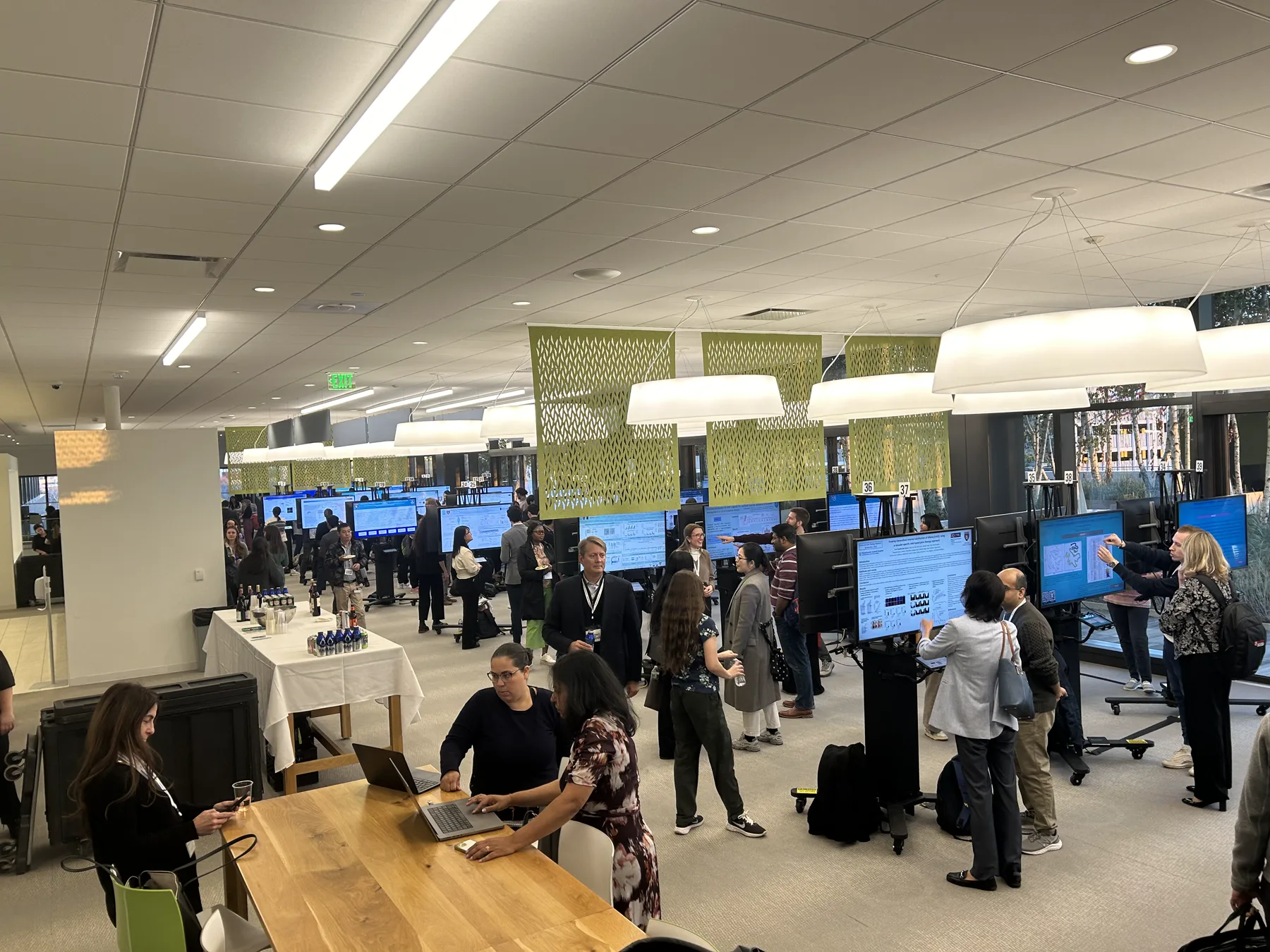 Attendees exploring digital poster displays in a conference room