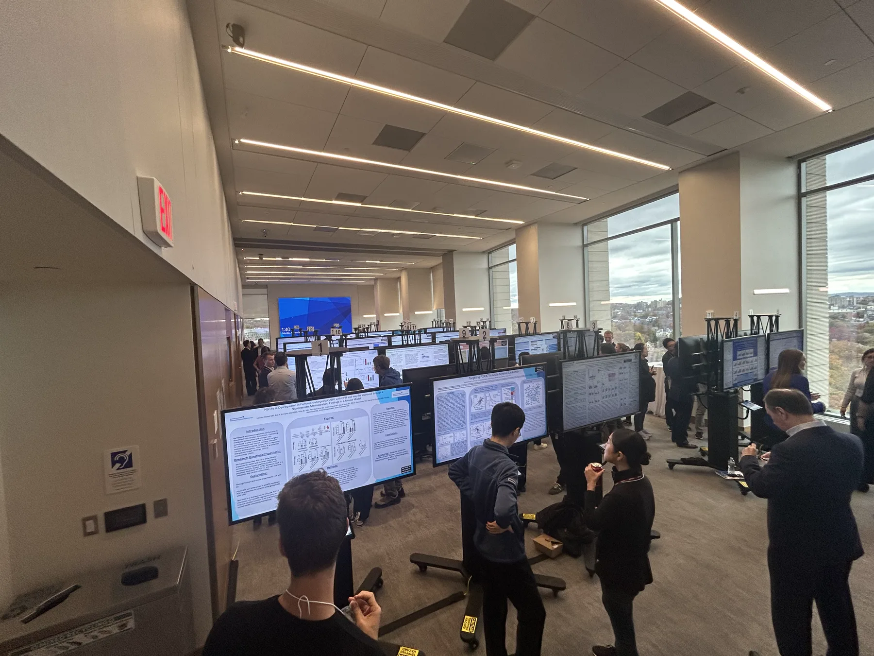 Digital poster displays arranged in a bright conference hallway