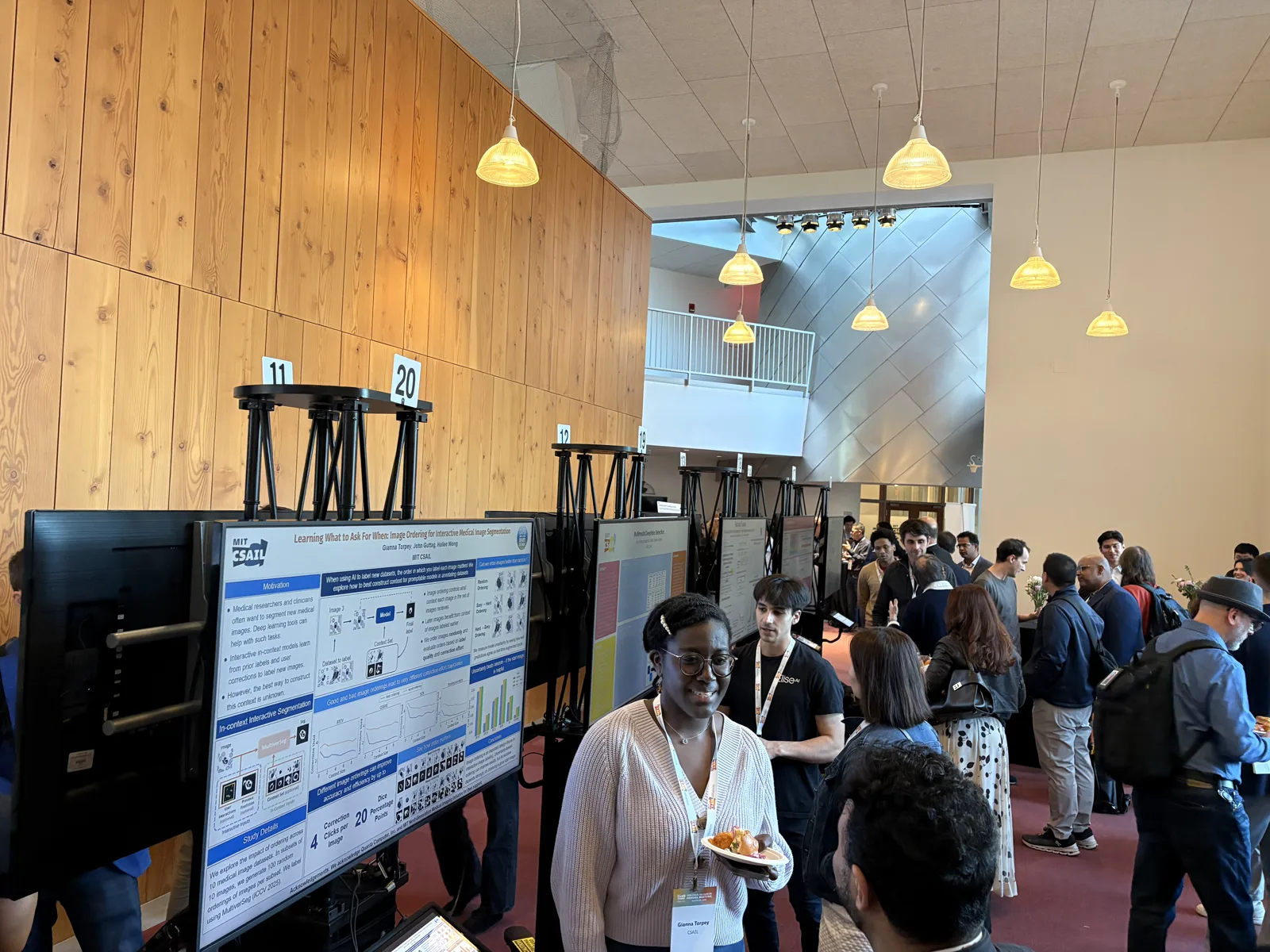 Attendees gathering around digital ePoster boards at a conference