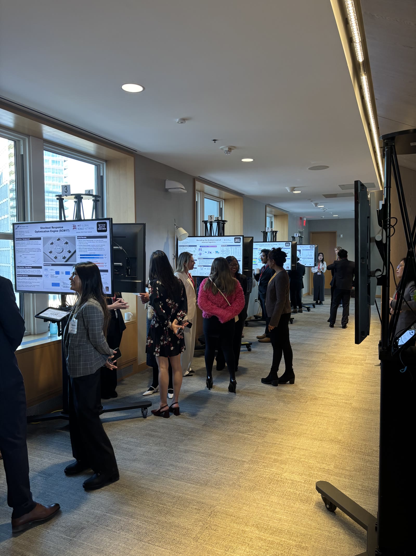 Attendees exploring digital posters along a conference hallway