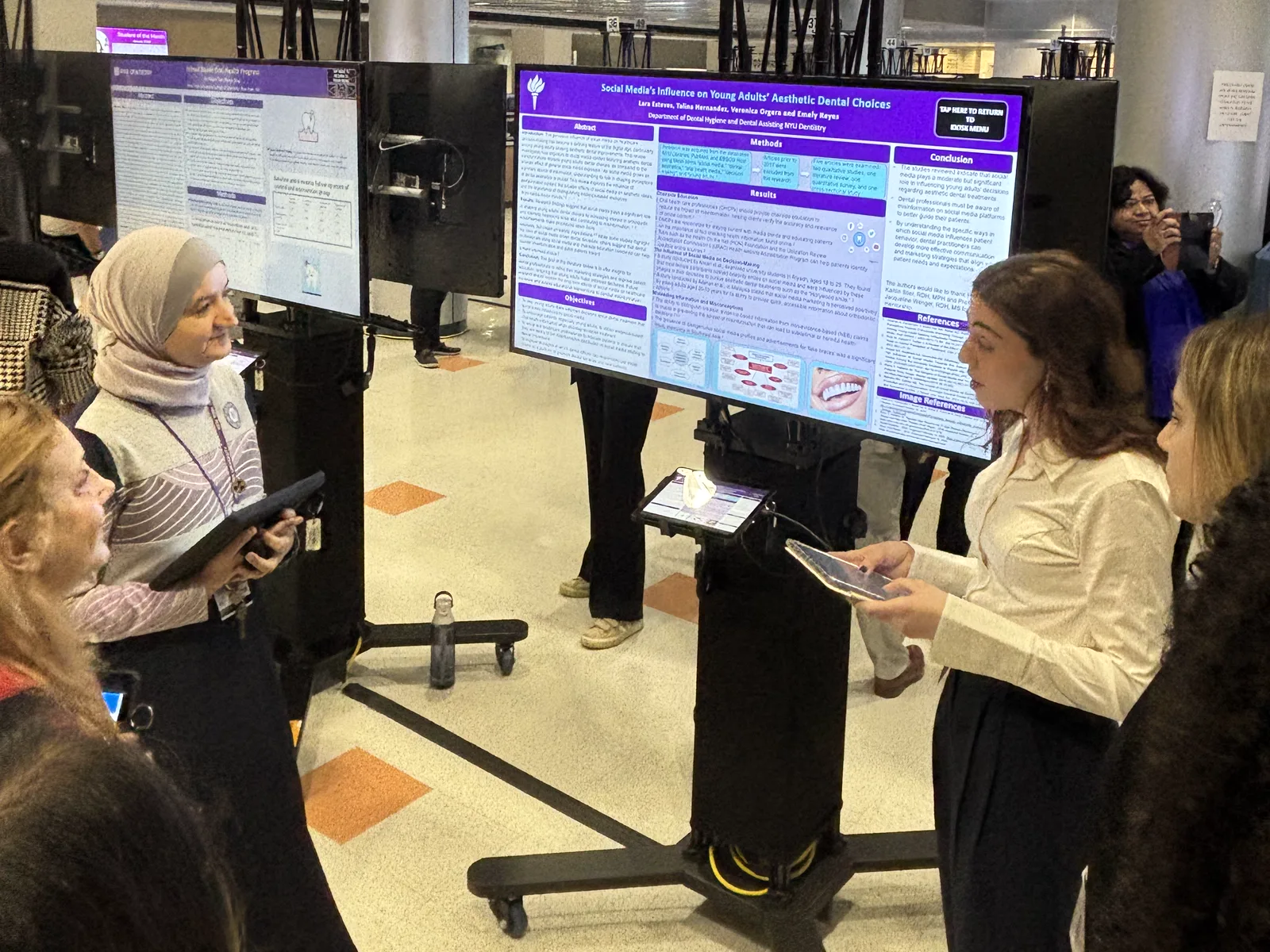 Attendees reviewing digital ePoster presentations during a judging session