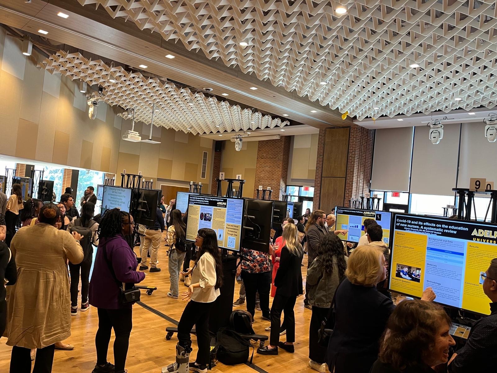 Attendees gathering around digital poster displays at a conference