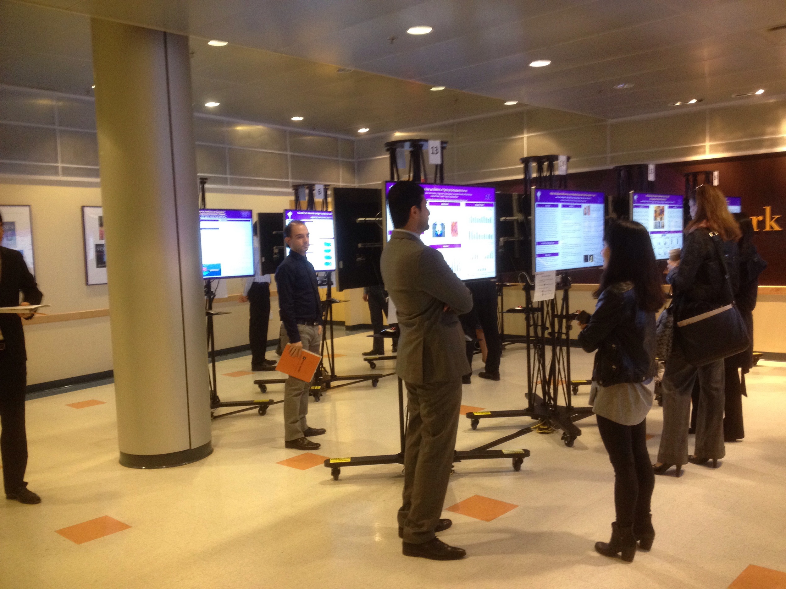 Attendees viewing digital poster displays at a conference
