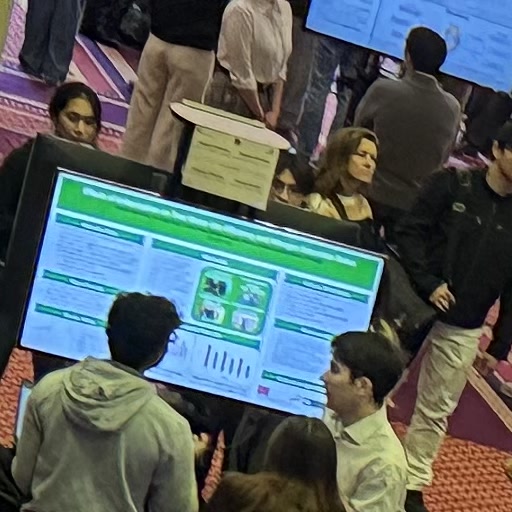 A long row of digital poster boards with attendees